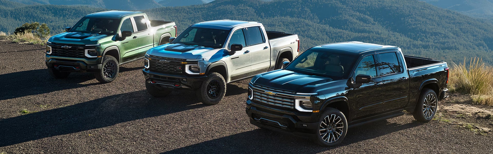 Three 2027 Chevrolet 1500 parked on the scenic mountain landscape.