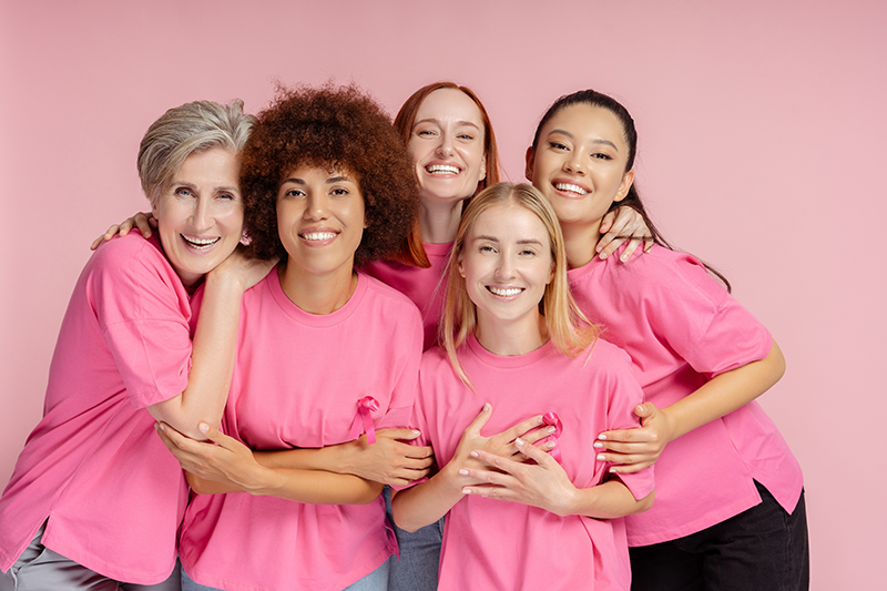 Group of diverse women wearing pink shirts for breast cancer awareness