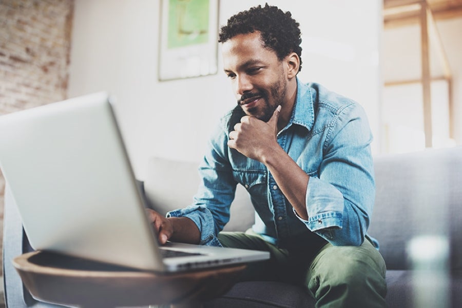 Man using a laptop at home for online car shopping